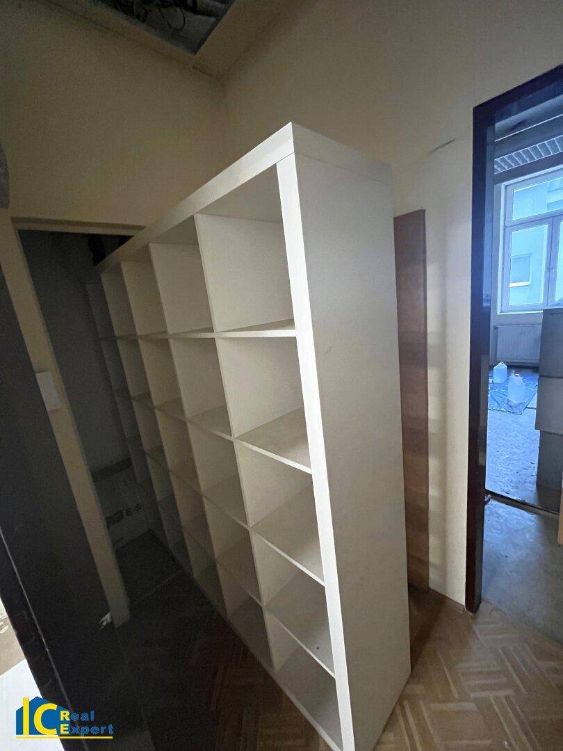 Schmaler Raum mit einem großen, weißen Regalsystem, das viel Stauraum bietet und gut erhalten ist.