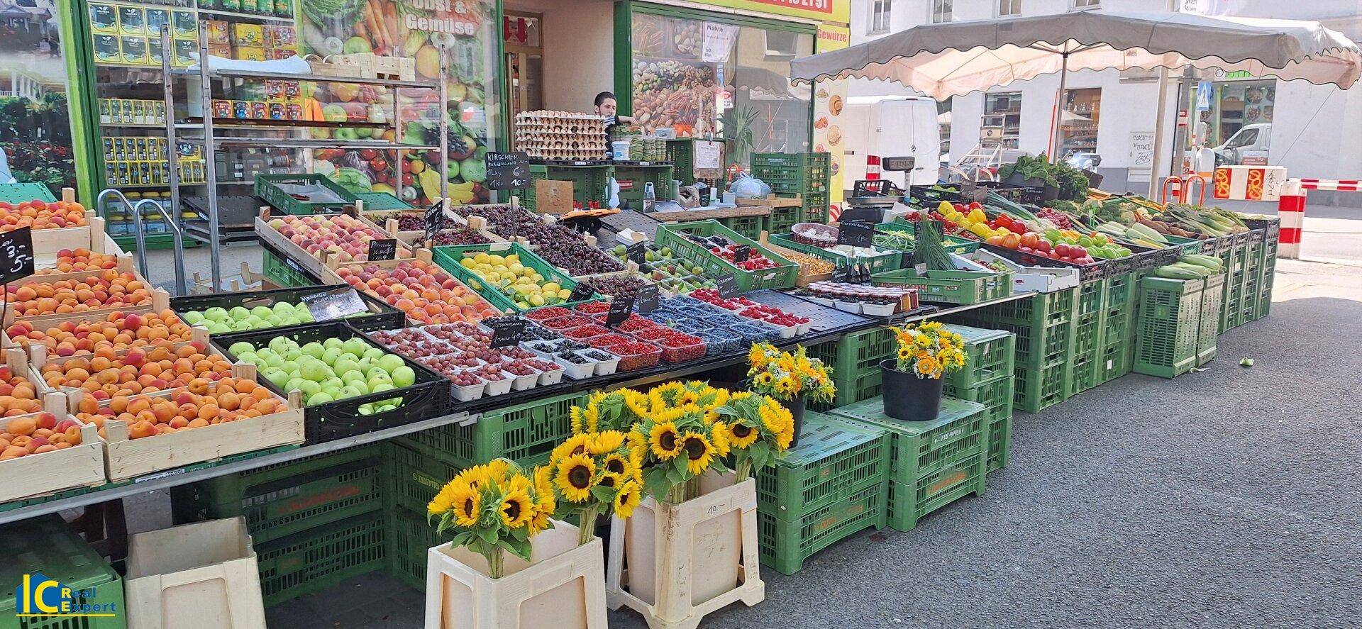 Bunter Obst- und Gemüsestand auf einem Markt mit frischen Produkten.