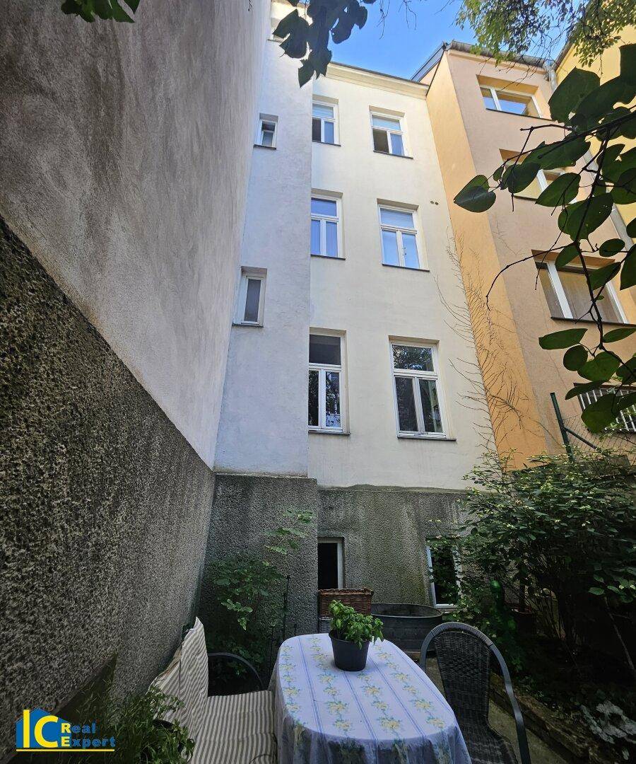 Ruhiger Innenhof mit Sitzgelegenheiten und Blick auf die umliegenden Gebäudefassaden, ideal zum Entspannen.