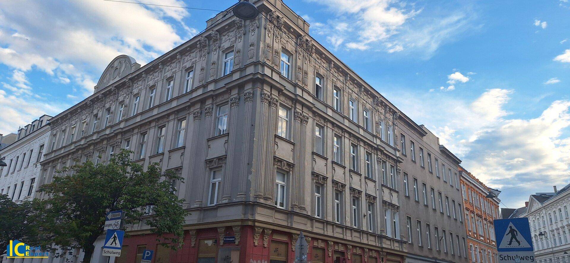 Eindrucksvolles Eckgebäude mit historischer Architektur und detaillierten Fassadenverzierungen unter blauem Himmel.
