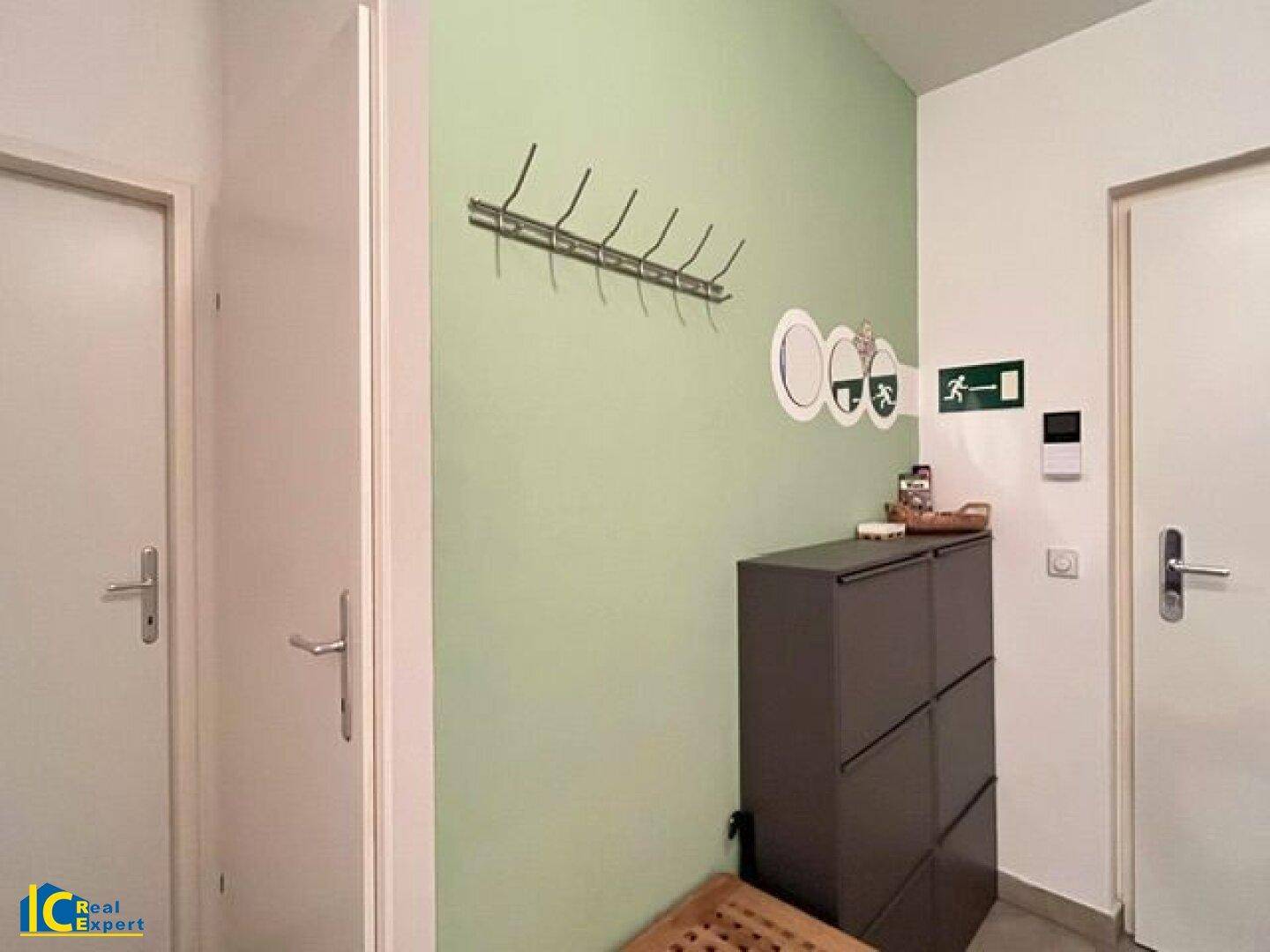 Eingangsbereich mit grüner Akzentwand, Garderobe und Schuhschrank für Ordnung.