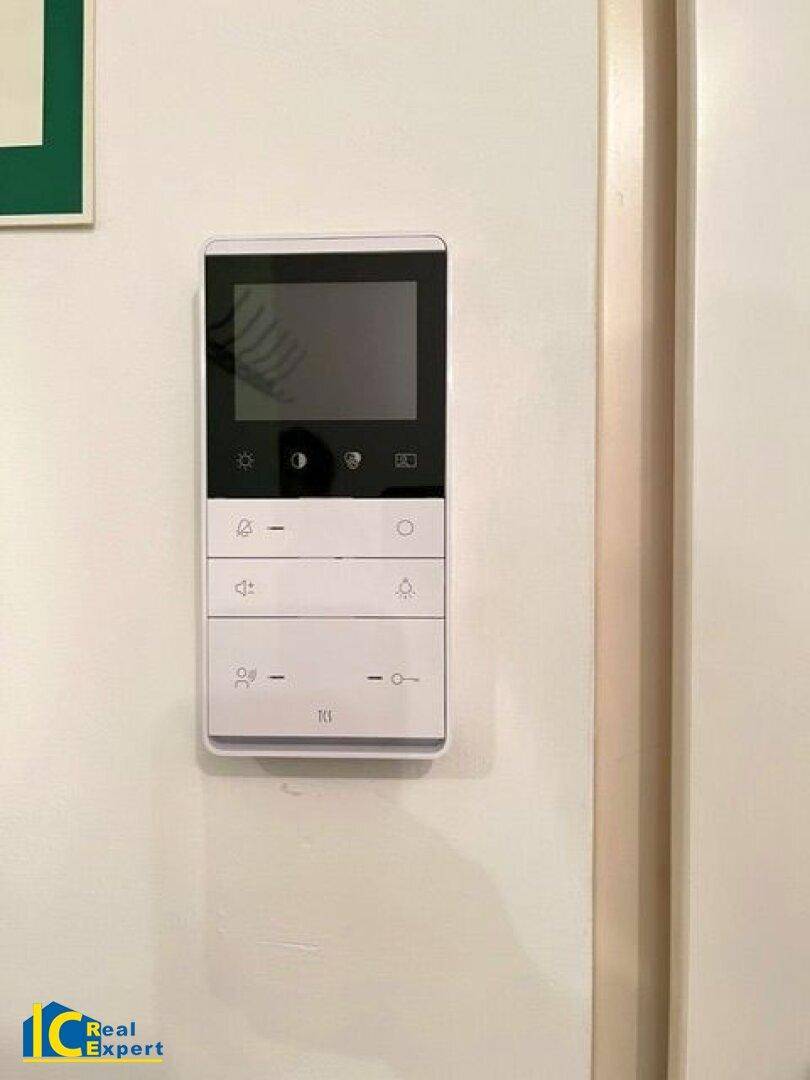 Moderne Gegensprechanlage mit Bildschirm an der weißen Wand im Eingangsbereich.