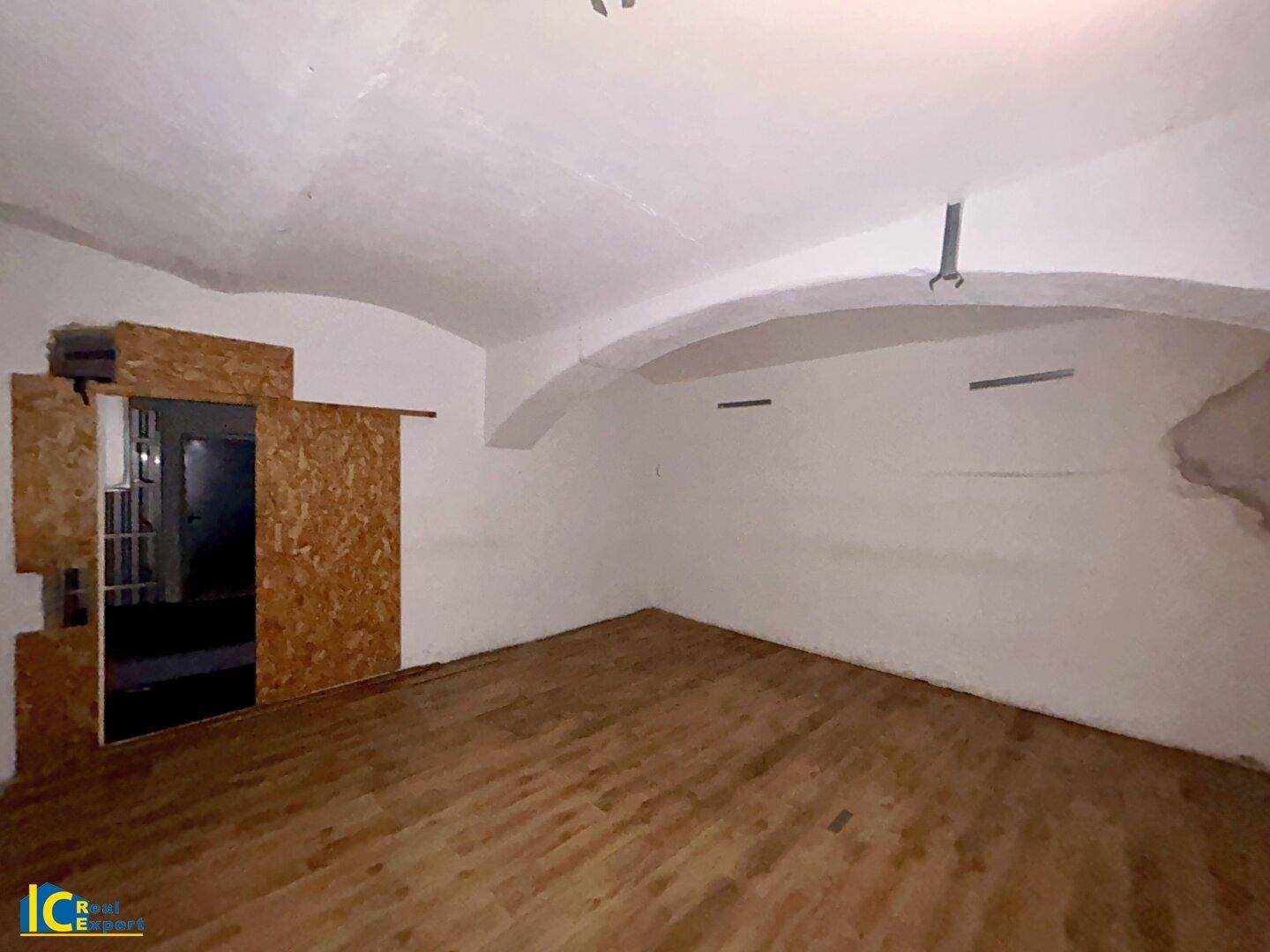 Kellerraum mit Holzboden und gewölbter Decke, bereit für Renovierung.