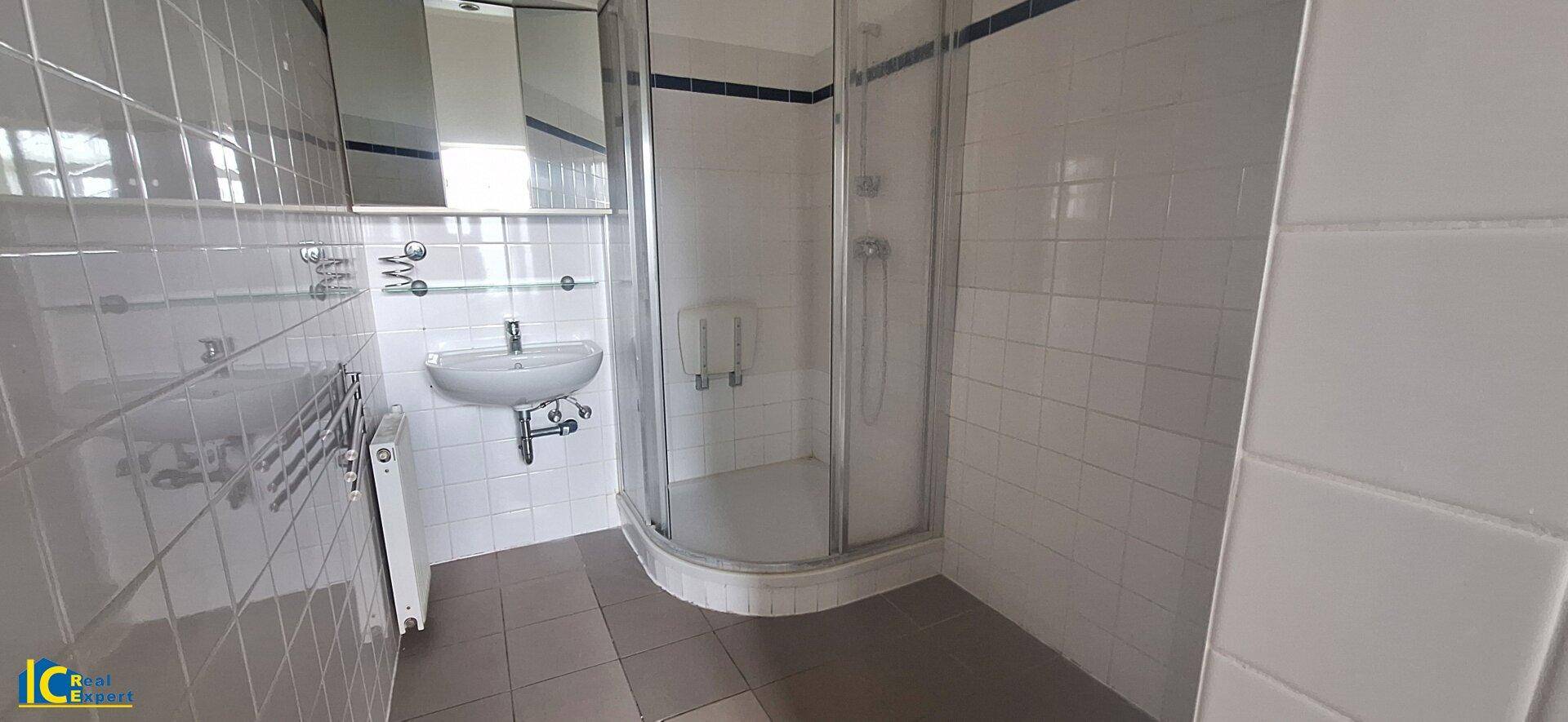 Freundliches Badezimmer mit Eckdusche und WM-Anschluss