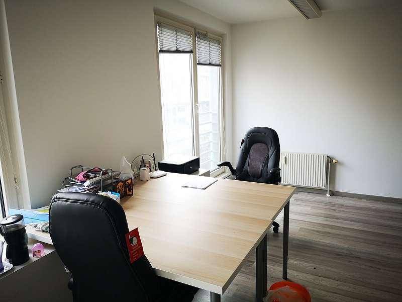 Büroraum mit Schreibtisch, Bürostuhl und Heizkörper unter dem Fenster.