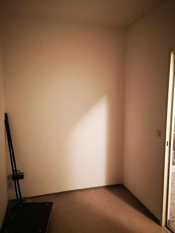 Heller Abstellraum mit weißen Wänden und einem kleinen Fenster oder Lichtschacht.