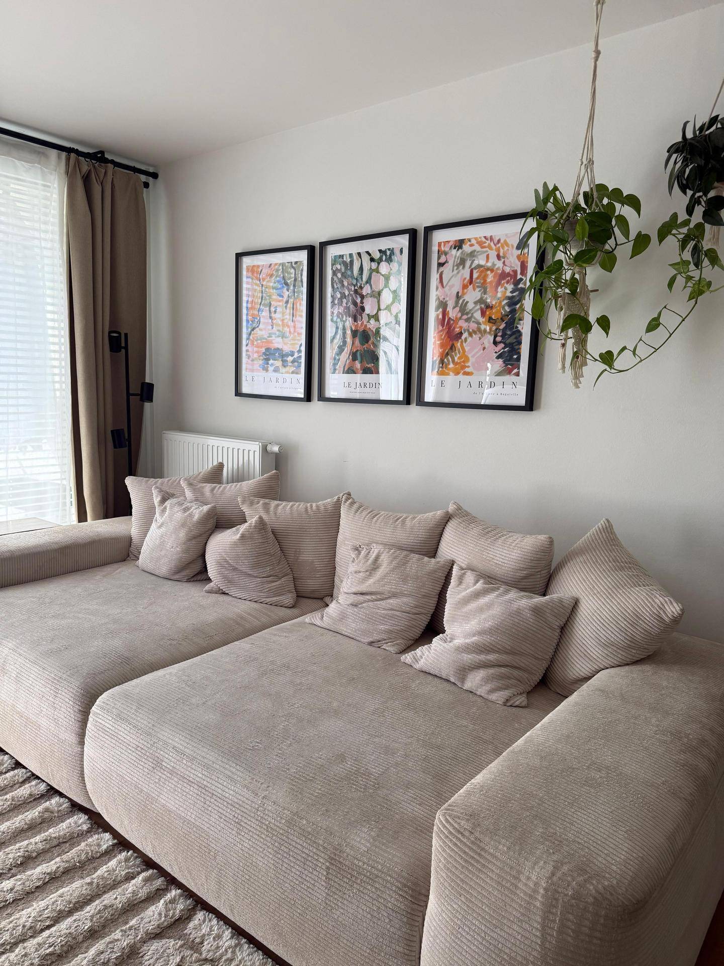 Nahaufnahme des bequemen Sofas und der modernen Wanddekoration im hellen Wohnzimmer.
