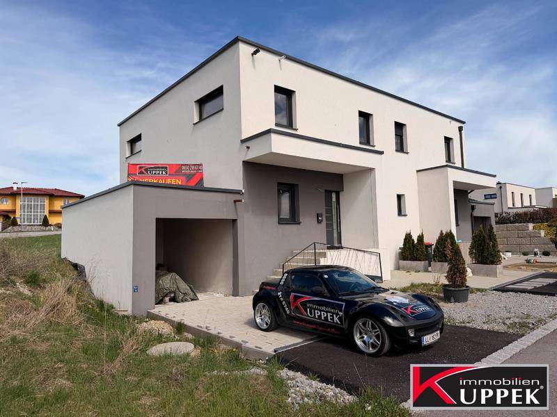 Zeitgenössisches Wohnhaus mit klaren Linien und integrierter Garage im Außenbereich.