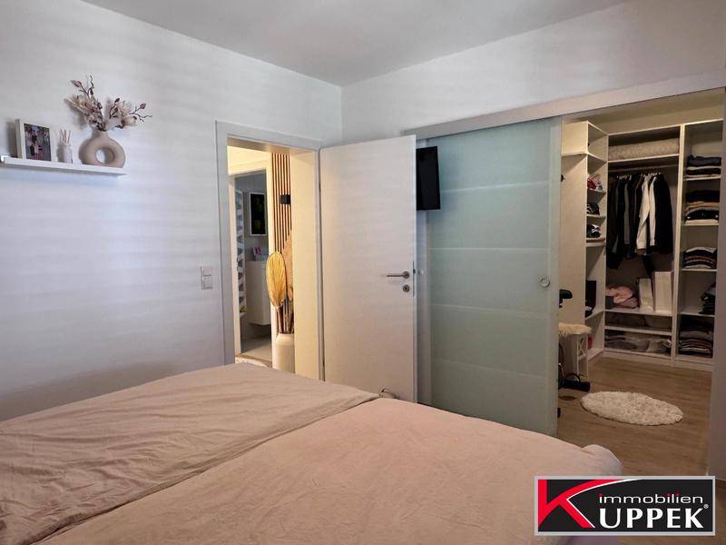 Helles Schlafzimmer mit Zugang zu einem begehbaren Kleiderschrank und Badezimmer.