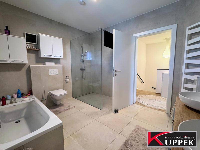 Geräumiges Badezimmer mit begehbarer Dusche, Badewanne und modernem Design.
