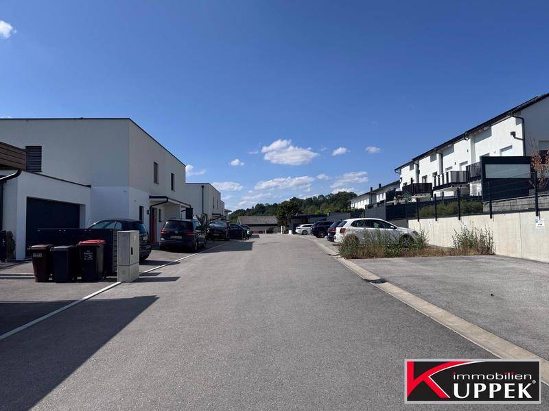 Ruhige Wohnstraße mit modernen Häusern und gepflegten Vorgärten.