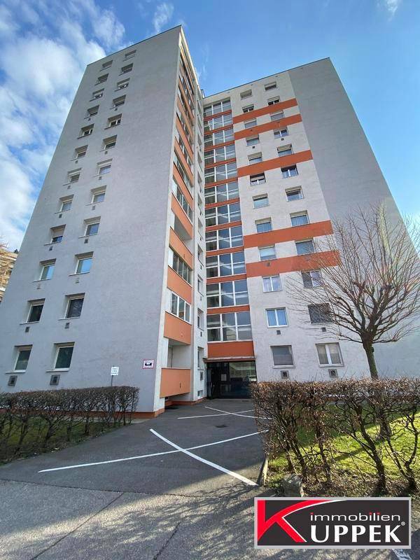Hohes Wohngebäude mit moderner Fassade, vielen Fenstern und Balkonen.