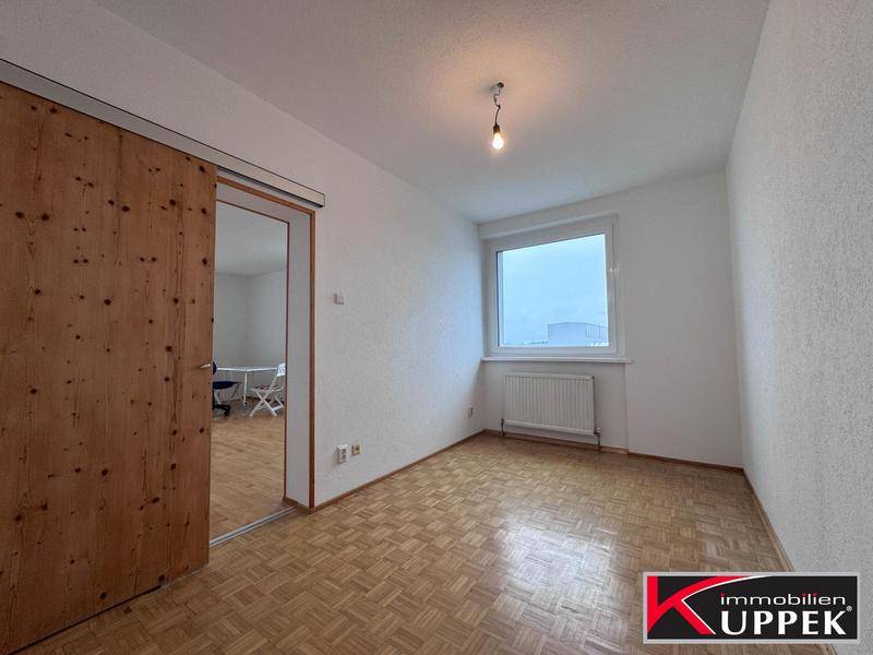 Leeres Zimmer mit Parkettboden und Fenster, bereit zur individuellen Gestaltung.