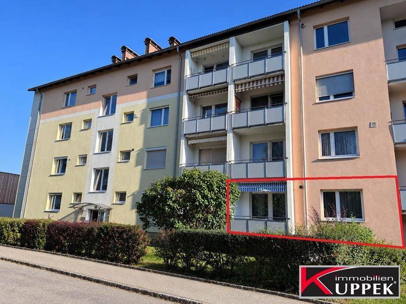 Mehrfamilienhaus mit mehreren Balkonen und gepflegter Außenanlage in sonniger Lage.
