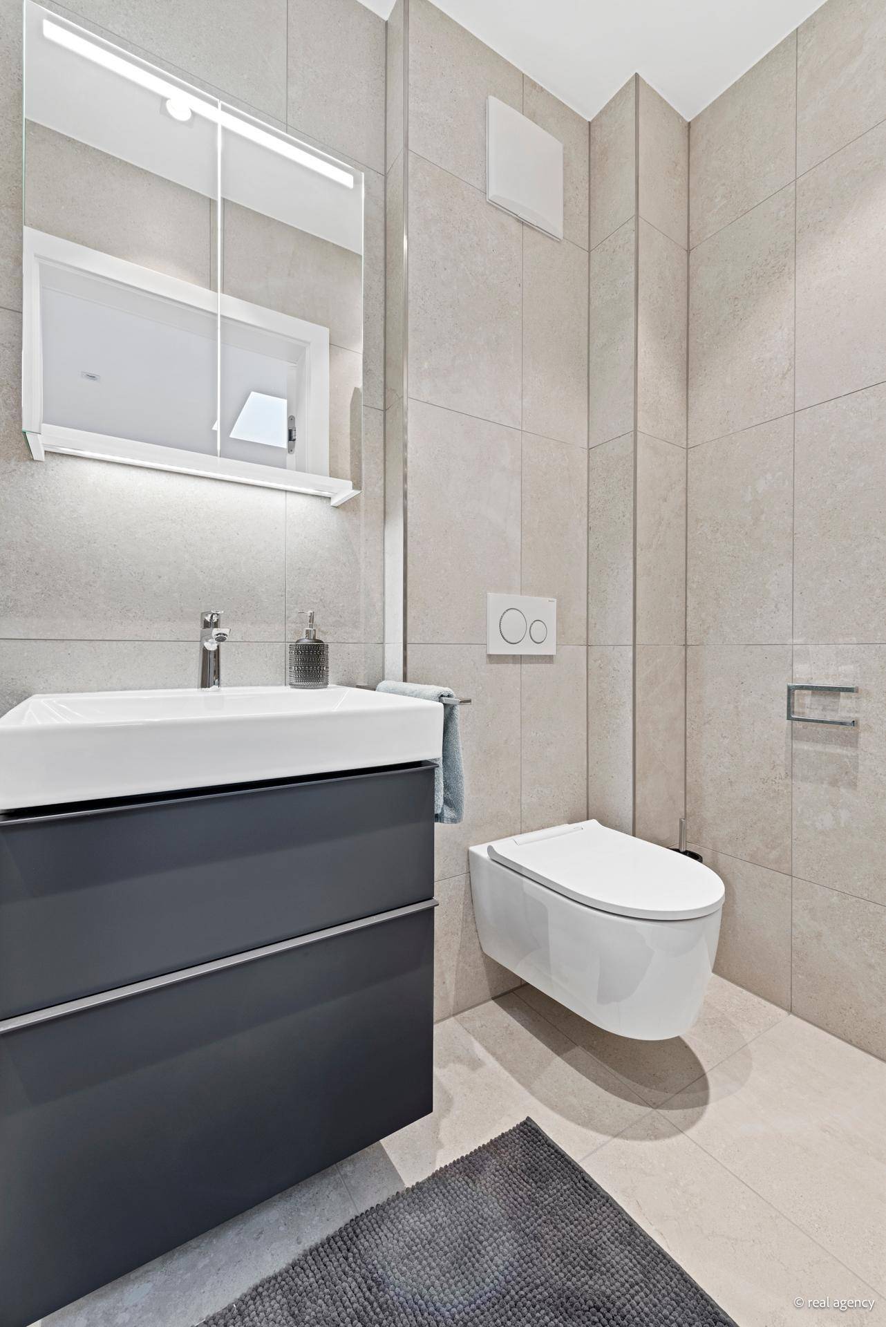 Kompaktes Gäste-WC mit modernem Design, Einzelwaschbecken und wandhängender Toilette.