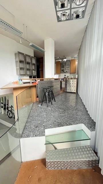 Offener Küchenbereich mit Bar und Arbeitsplatte, verbunden mit einem unteren Bereich durch eine Treppe.