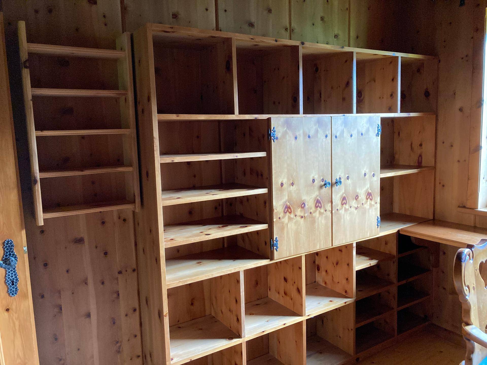 Maßgefertigtes Bücherregal aus Holz mit integrierten Schränken im Arbeitszimmer.