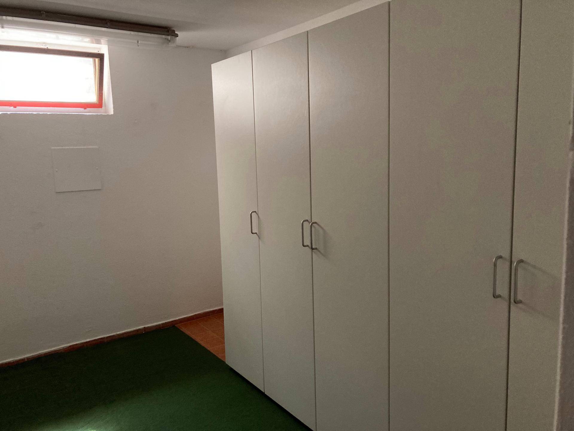 Raum mit praktischen Einbauschränken und einem kleinen Fenster für natürliche Belüftung.