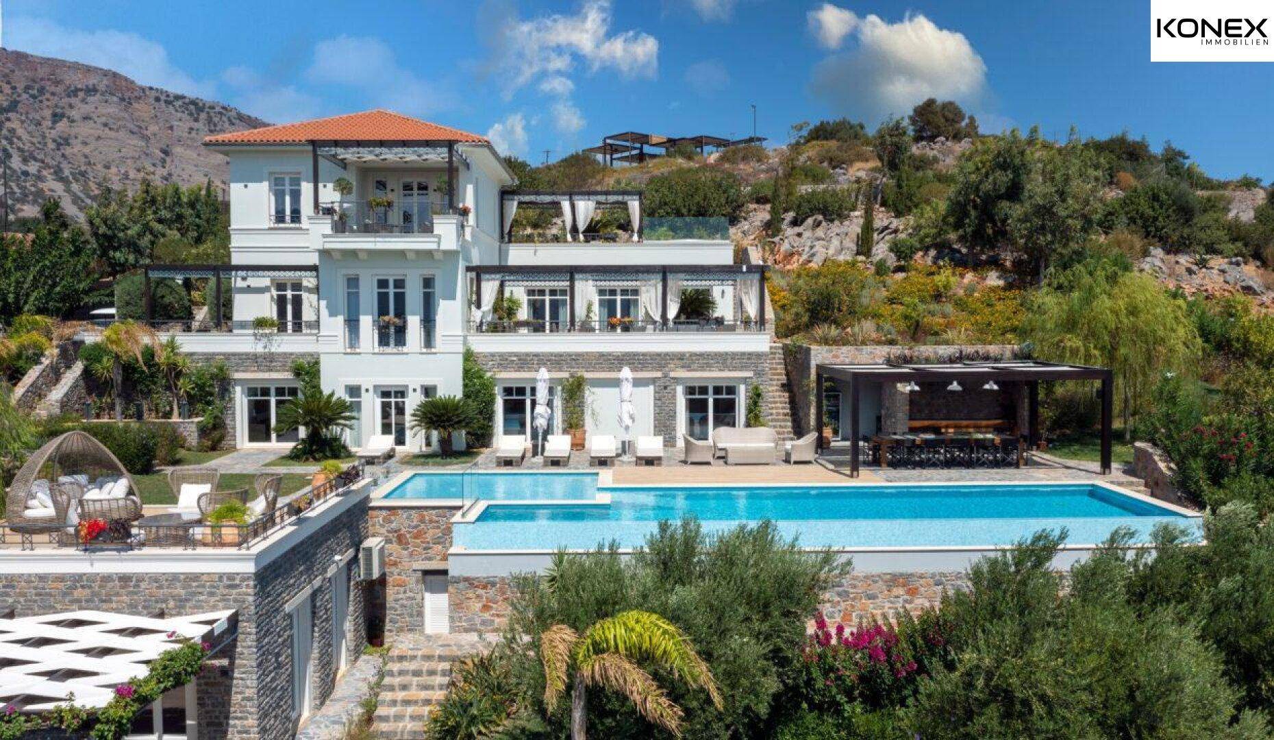 Beeindruckende Villa mit weitläufigem Poolbereich und Terrassen, eingebettet in eine grüne Hügellandschaft.