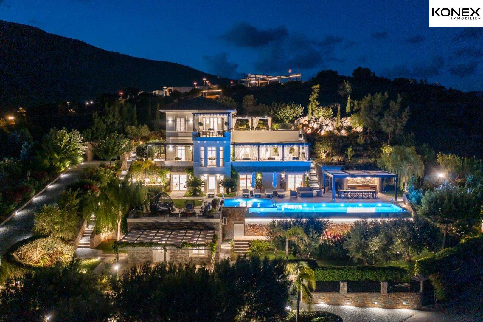 Beeindruckende Nachtansicht der luxuriösen Villa mit beleuchteten Terrassen und Poolbereich.