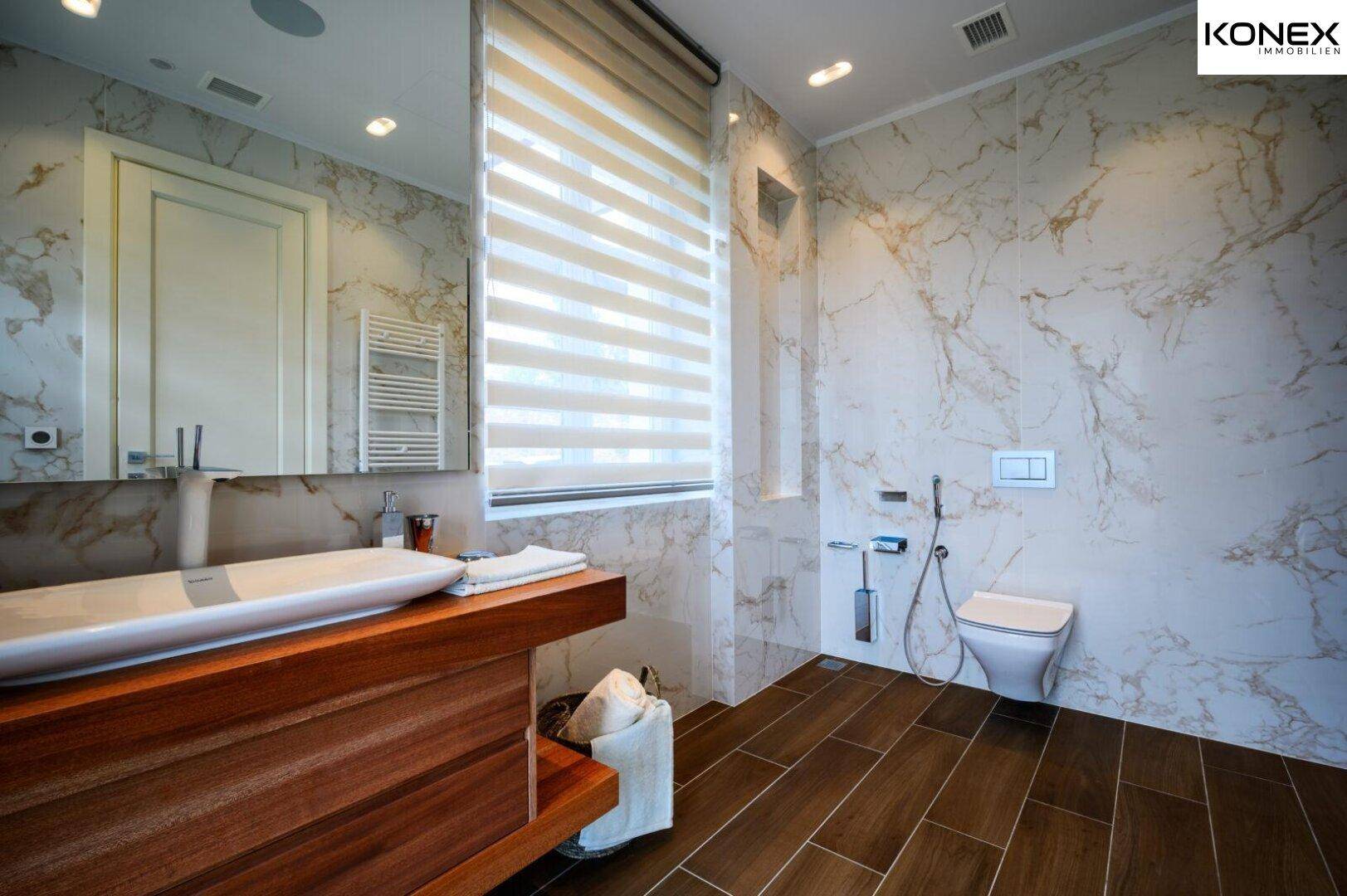 Modernes Badezimmer mit Marmorfliesen, Holzwaschtisch und ebenerdiger Dusche.