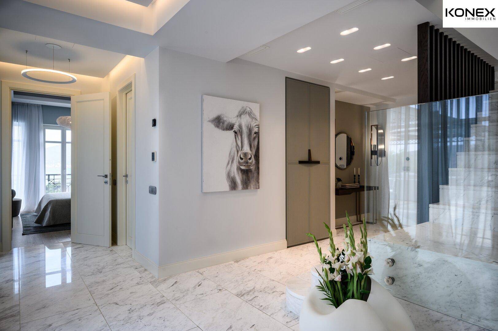 Heller Flur mit Marmorboden, moderner Kunst und Blick in angrenzende Räume.