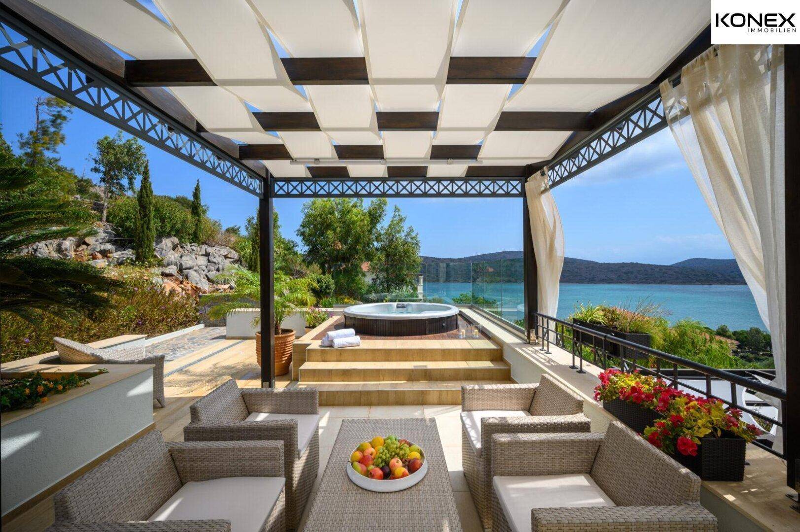 Geräumige Terrasse mit Whirlpool, Loungebereich und weitem Blick auf das Meer.