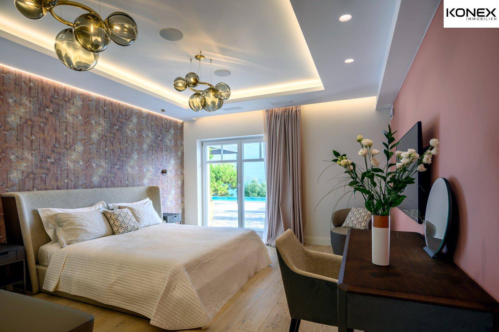 Luxuriöses Schlafzimmer mit Holzboden, strukturierter Wand und Zugang zum Poolbereich.