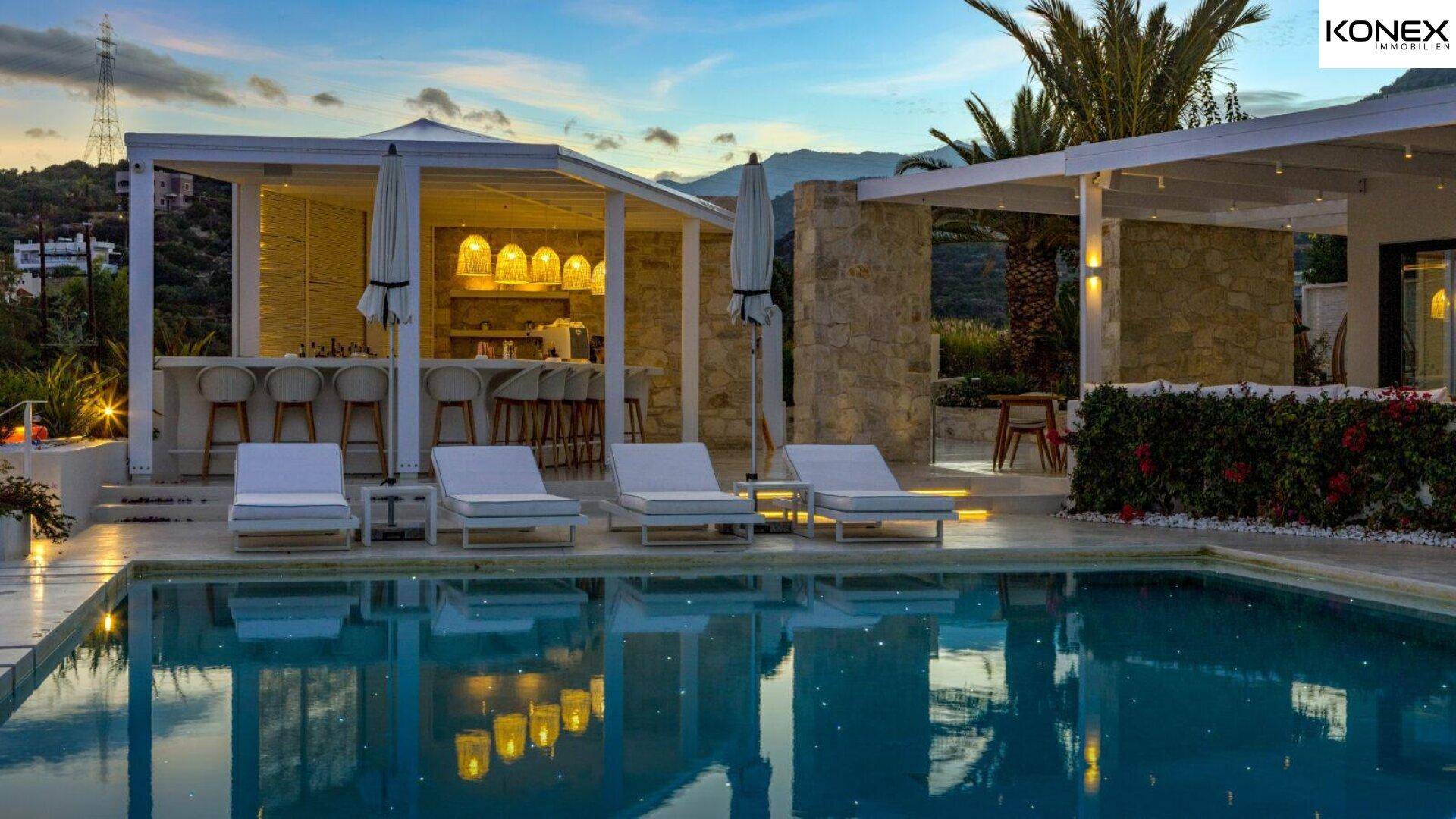 Stilvolle Außenbar neben dem Pool, ideal für entspannte Abende mit Blick auf die Umgebung.