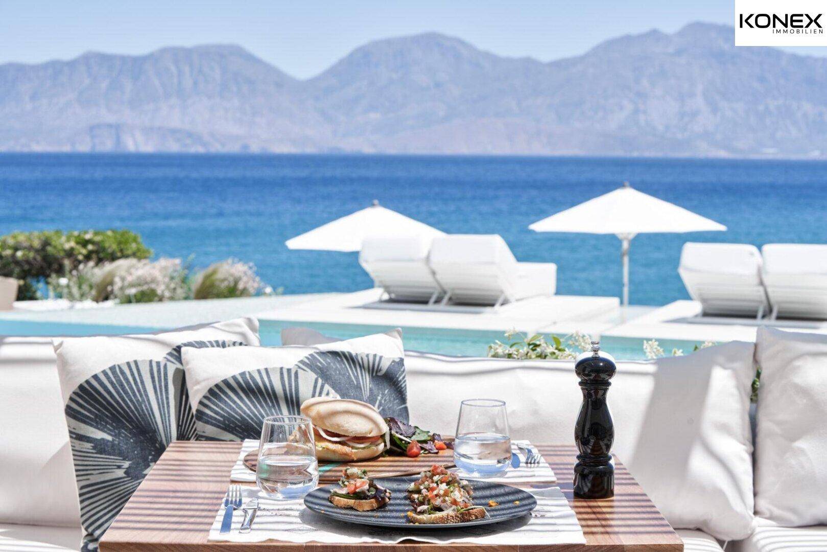 Frühstückstisch im Freien mit Blick auf den Pool und das weite, blaue Meer.