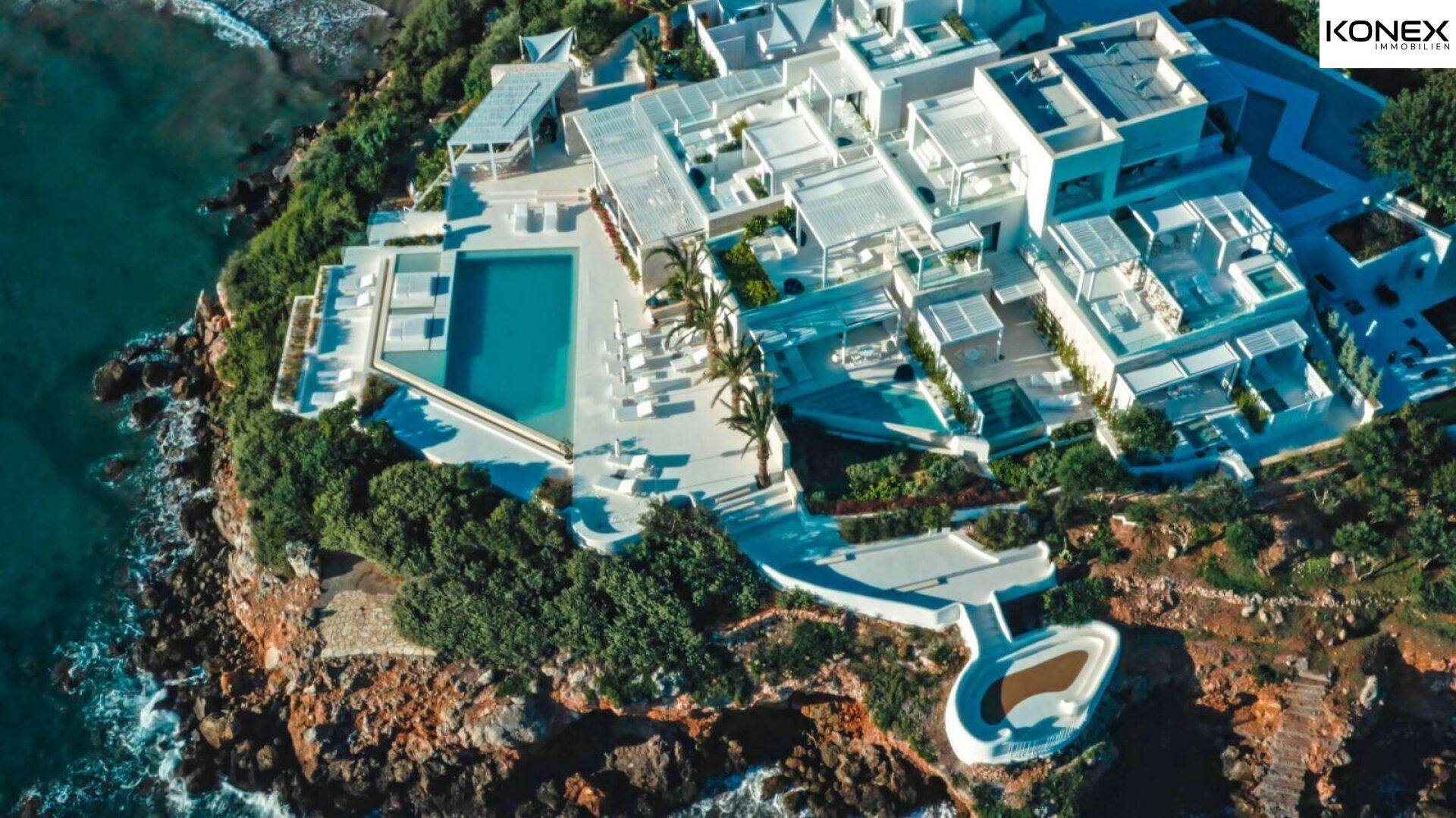 Weitläufige Luftaufnahme der gesamten luxuriösen Anlage an der Küste mit Pools und Gebäuden.