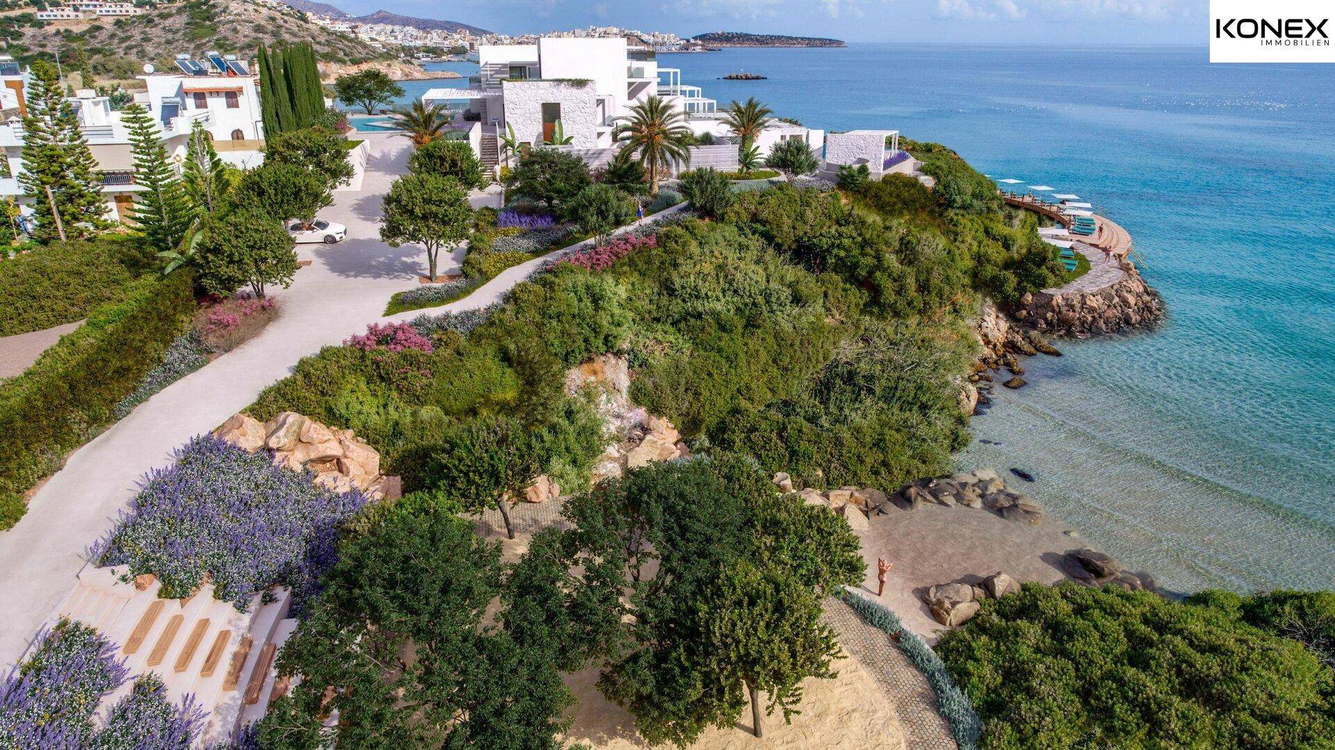 Luftaufnahme der gepflegten Gärten und der Küstenlinie der Anlage mit mediterraner Vegetation.
