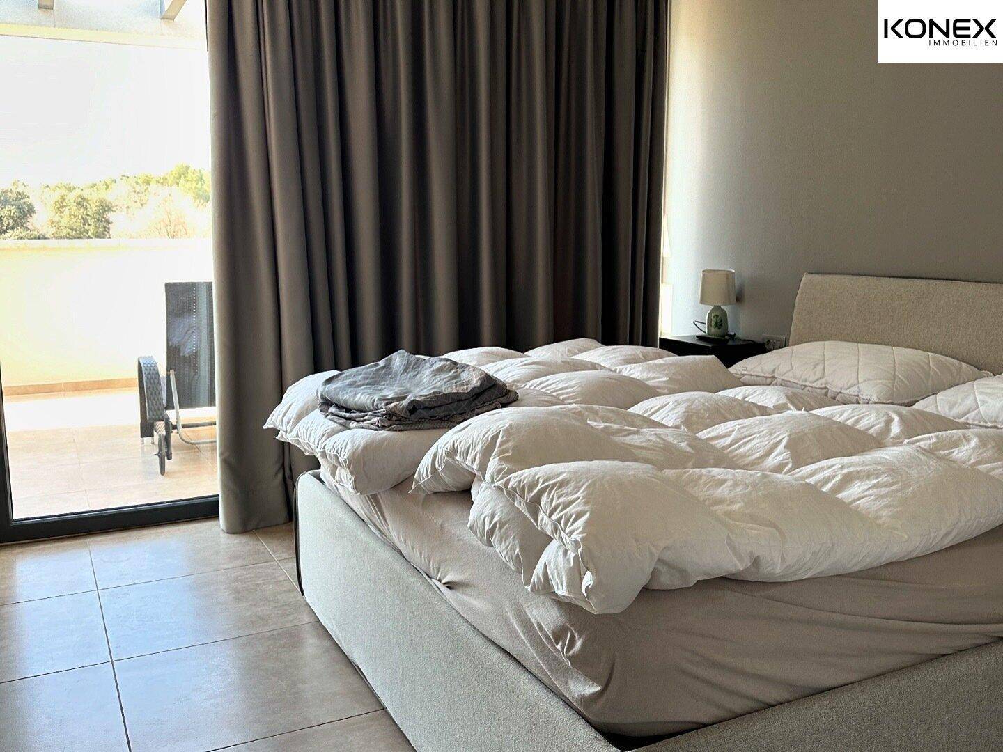 Schlafzimmer mit Zugang zu einem Außenbereich und viel natürlichem Licht.