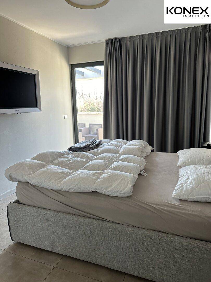 Schlafzimmer mit Zugang zu einem Außenbereich und viel natürlichem Licht.
