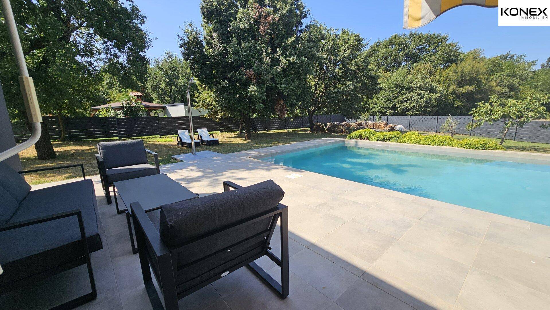 Möblierte Terrasse mit Lounge-Möbeln und direktem Zugang zum Swimmingpool.