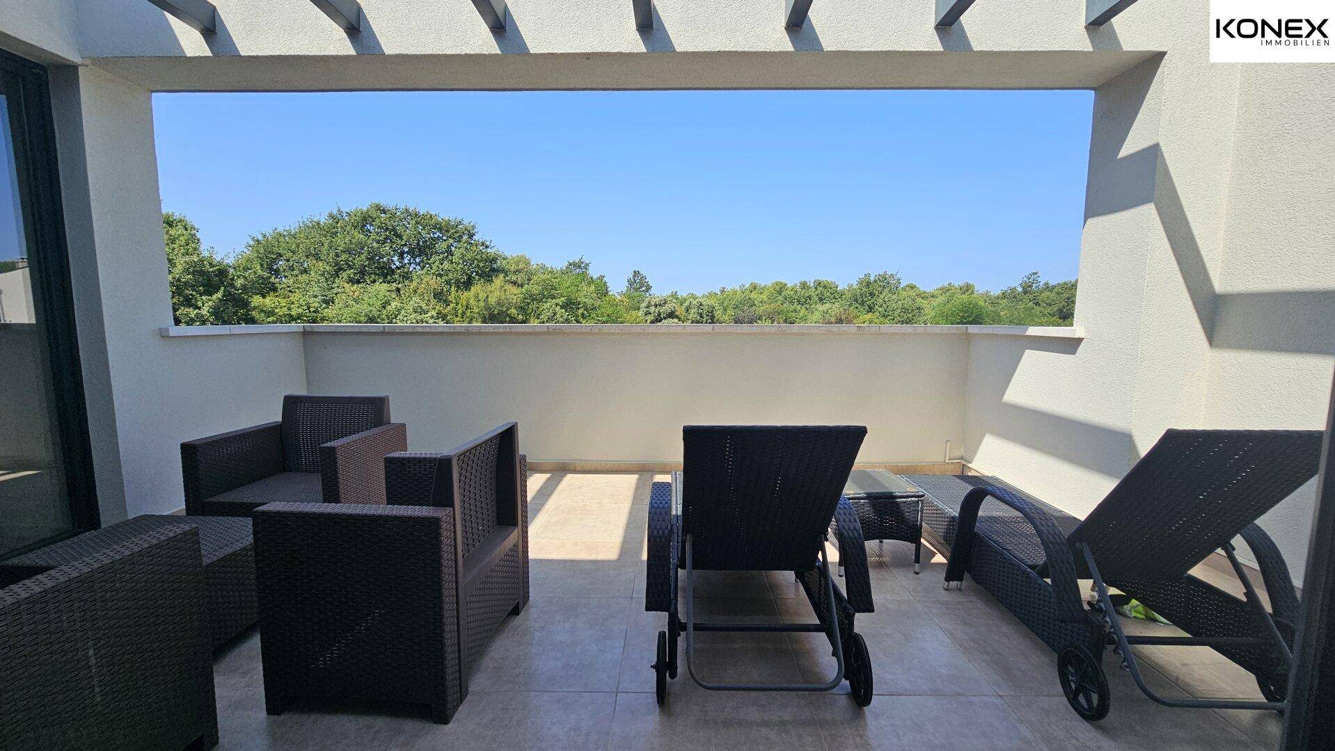 Möblierte Dachterrasse mit Lounge-Möbeln und weitem Blick in die Natur.