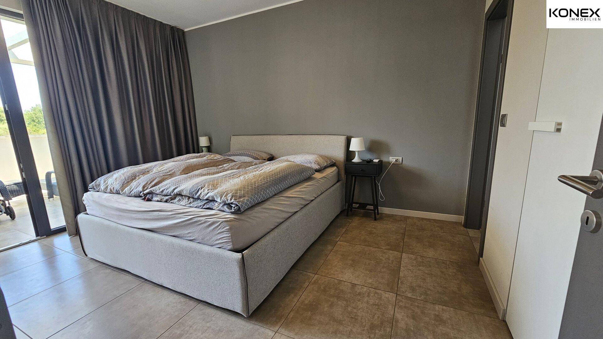 Schlafzimmer mit großem Bett und direktem Zugang zur Terrasse.