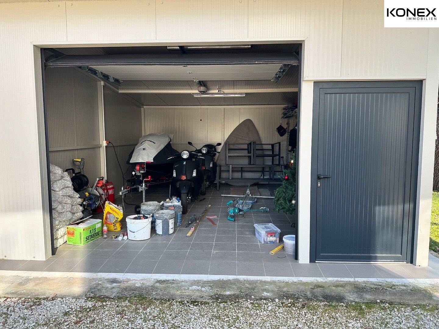 Geräumige Garage mit Stauraum, Werkzeugen und Platz für Fahrzeuge.