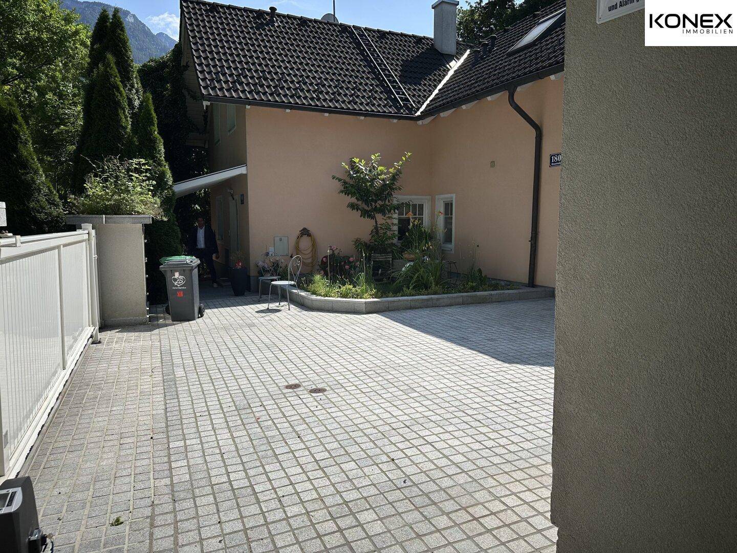Gepflasterte Einfahrt neben dem Haus mit einem kleinen Gartenbereich.