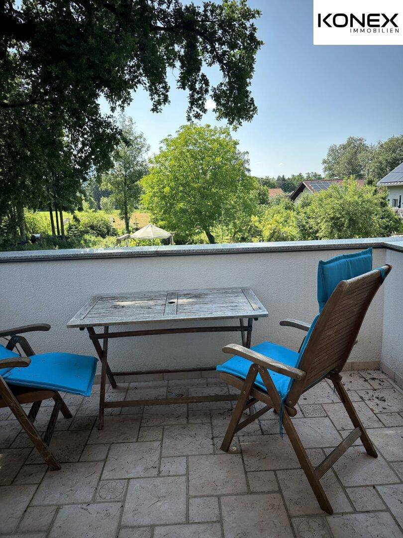 Kleiner Balkon mit Tisch und Stühlen, ideal für entspannte Stunden im Freien.