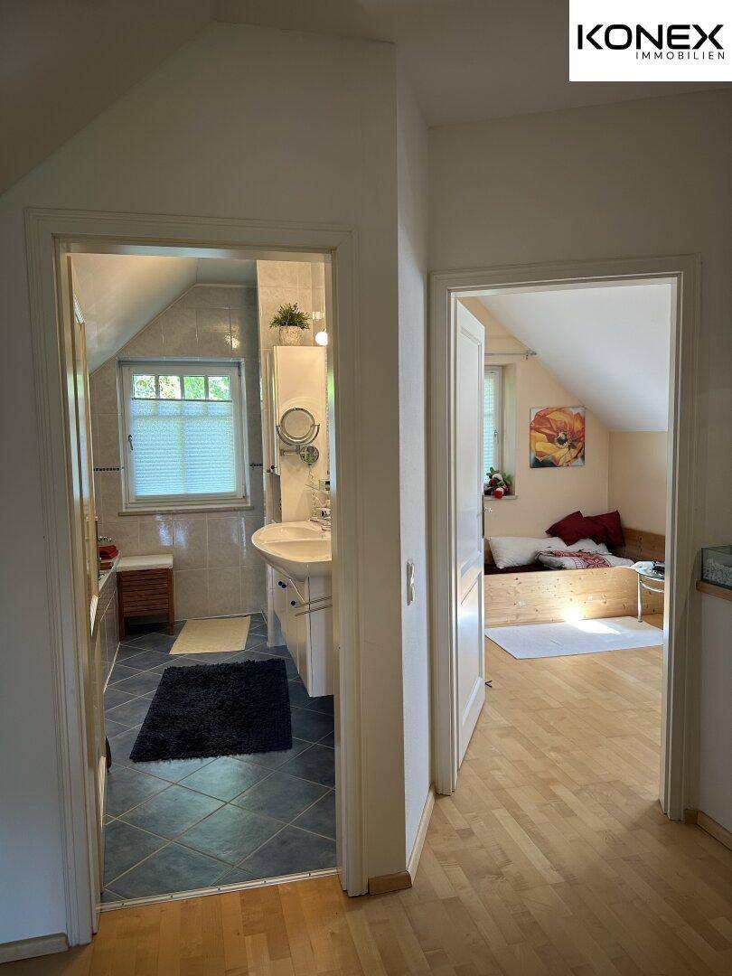 Heller Flur mit Blick in das Badezimmer und ein weiteres Zimmer.