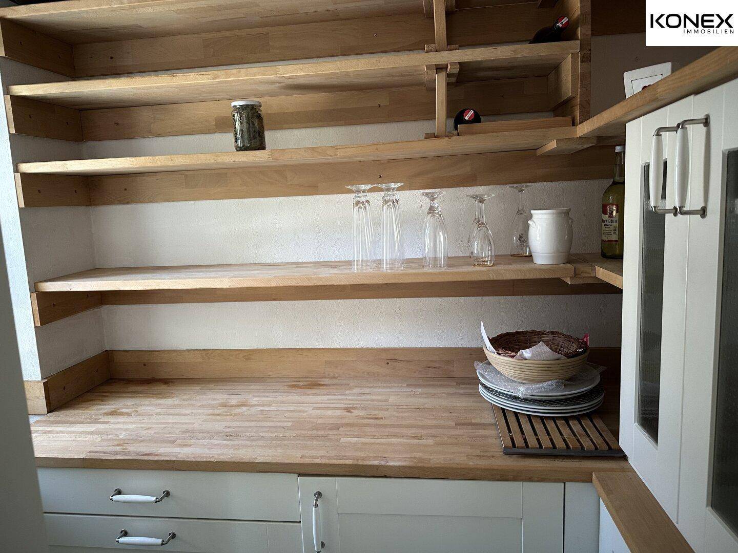 Offene Holzregale und Arbeitsplatte in der Küche, ideal für Geschirr und Vorräte.