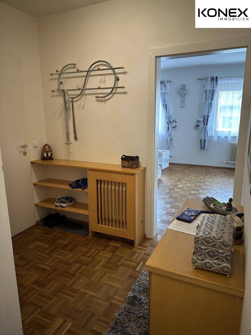 Heller Flur mit Garderobe, Schuhregal und Zugang zu weiteren Wohnbereichen.