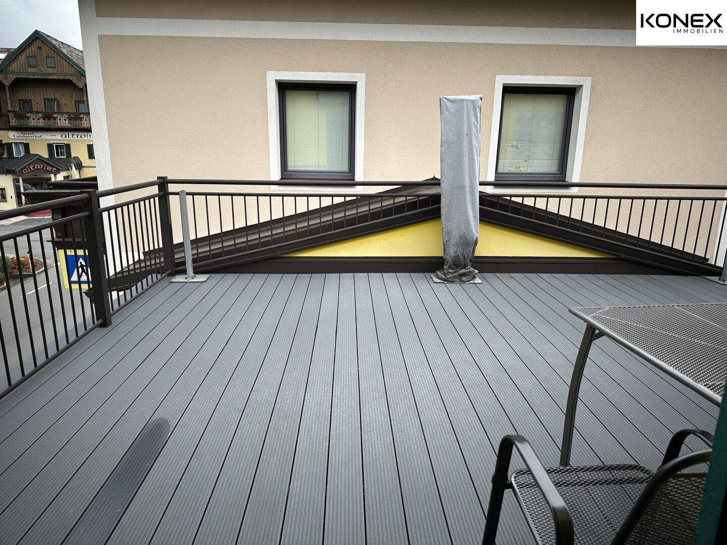 Geräumige Terrasse mit modernen Dielen und Blick auf die umliegenden Gebäude.