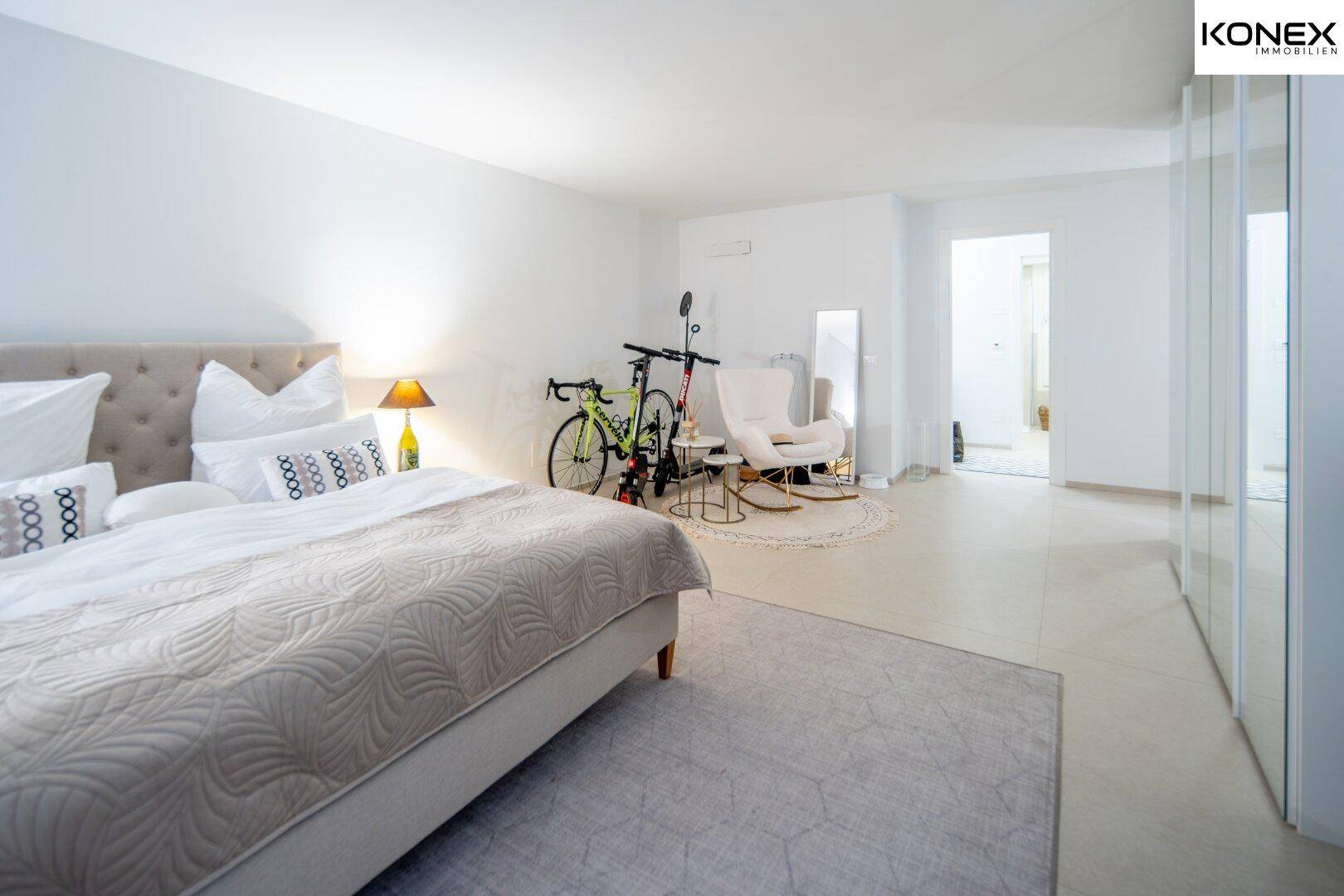 Großes Schlafzimmer mit Doppelbett, Teppichboden und Spiegelschränken, hell und geräumig.