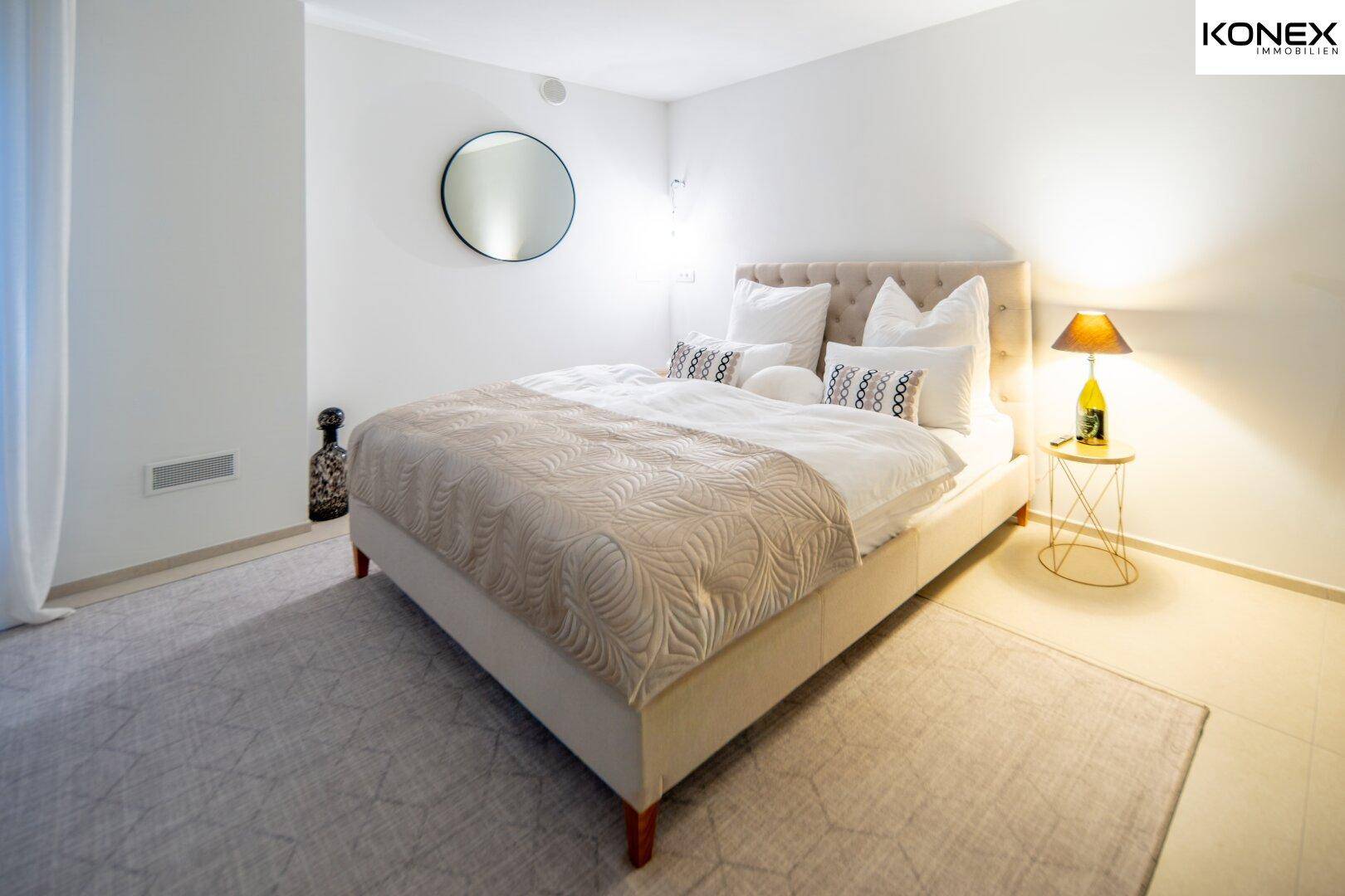 Gemütliches Schlafzimmer mit großem Doppelbett, Teppichboden und indirekter Beleuchtung.