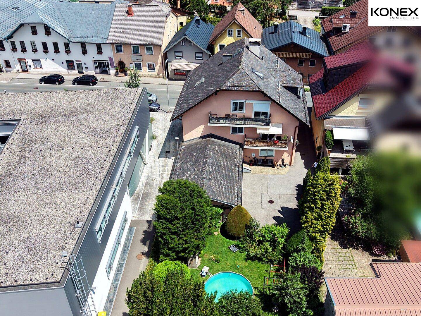 Rückansicht des Hauses mit Garten, kleinem Pool und angrenzenden Gebäuden.