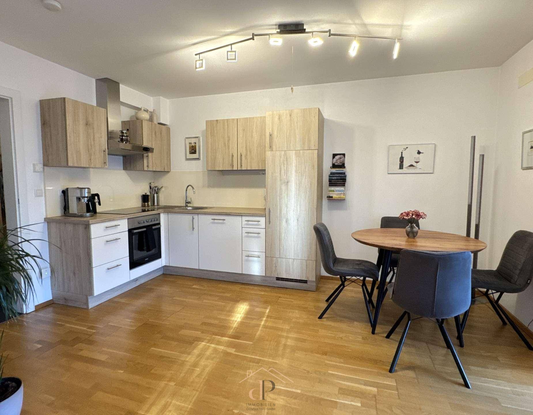 Moderne offene Küche mit hellem Holzdekor und Essbereich auf Parkettboden.