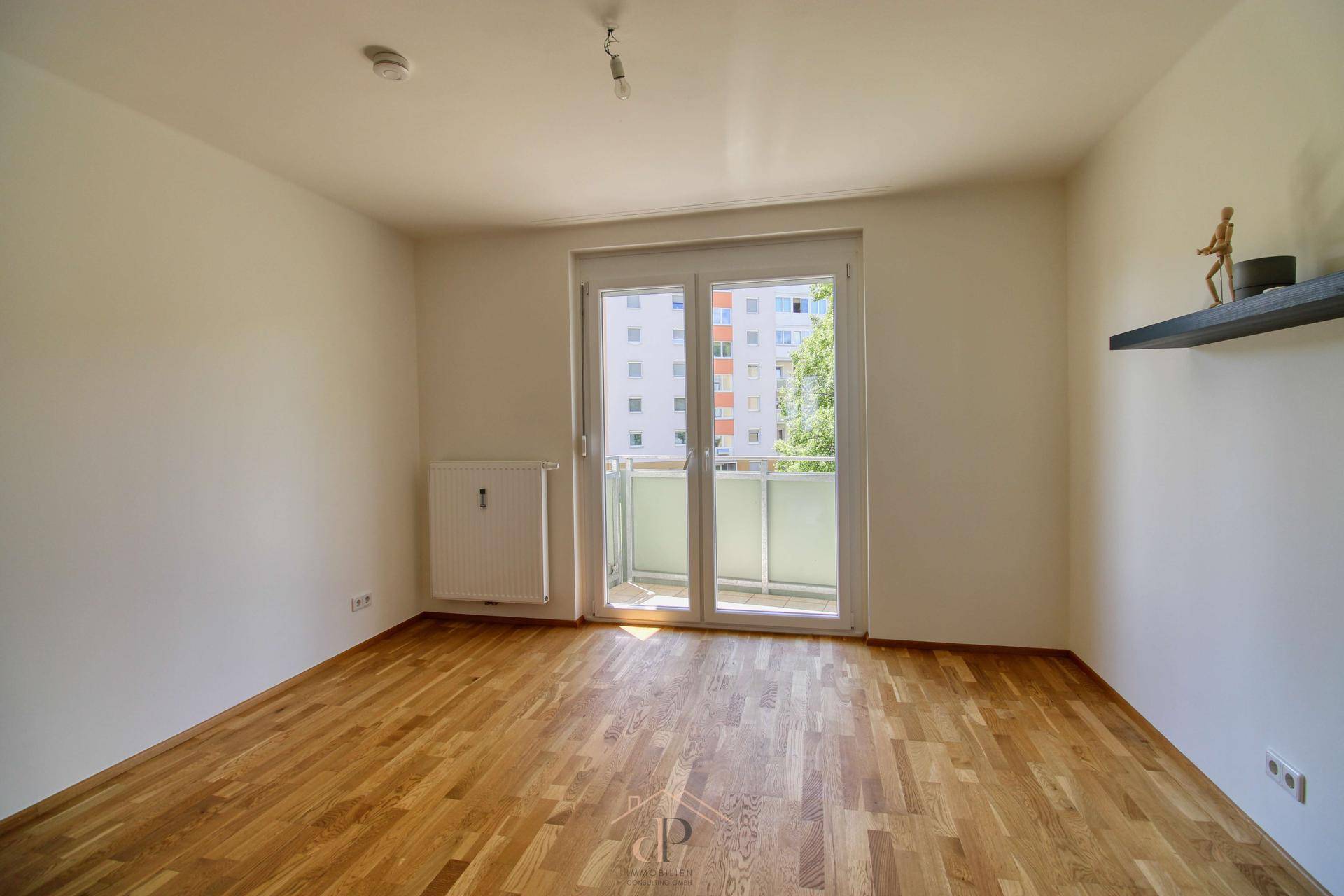 Schlafzimmer mit Holzboden und Balkonzugang, bietet einen Blick auf die Umgebung.
