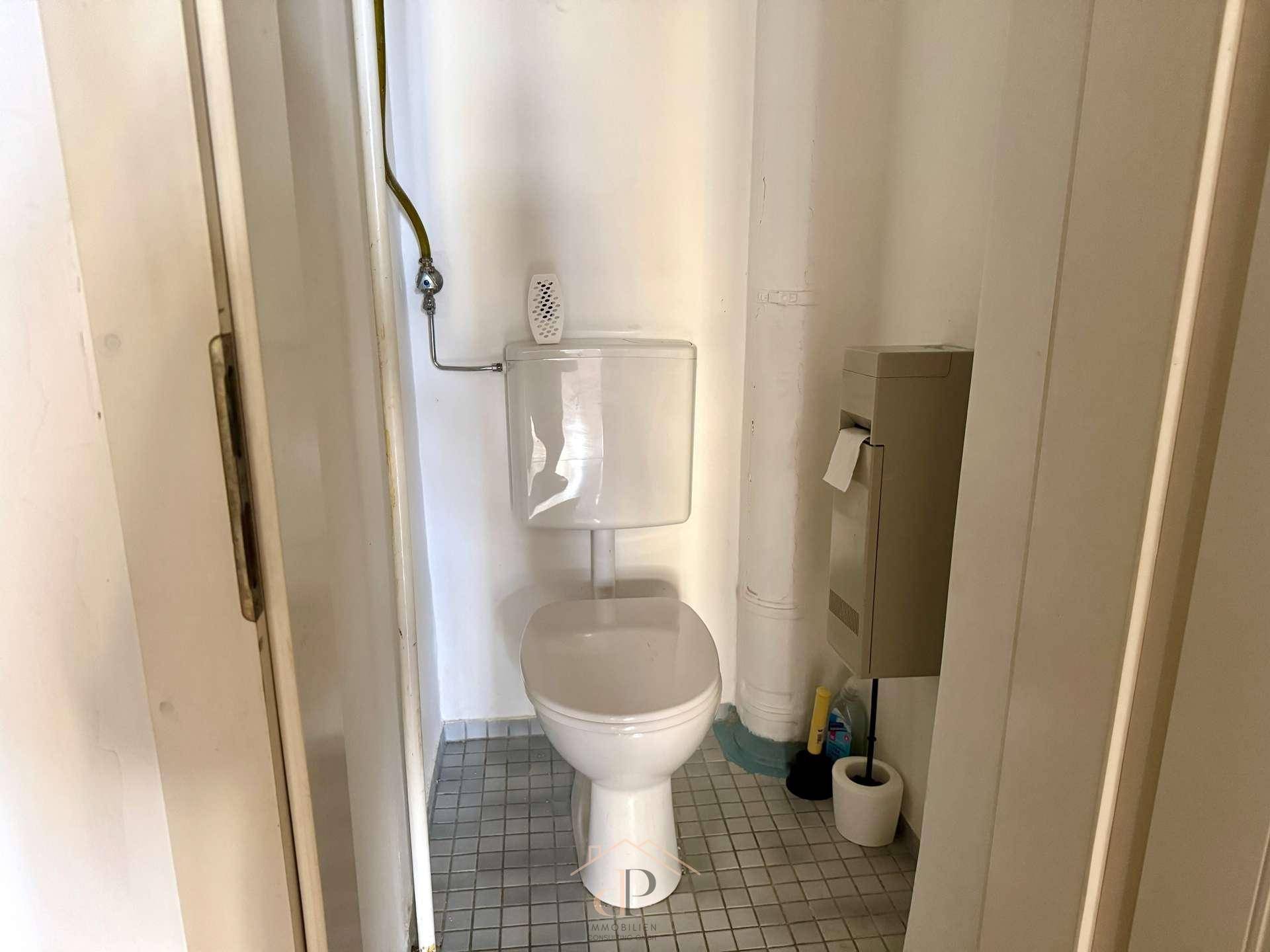 Separates WC mit Steh-WC und Fliesenboden, funktional und einfach gehalten.